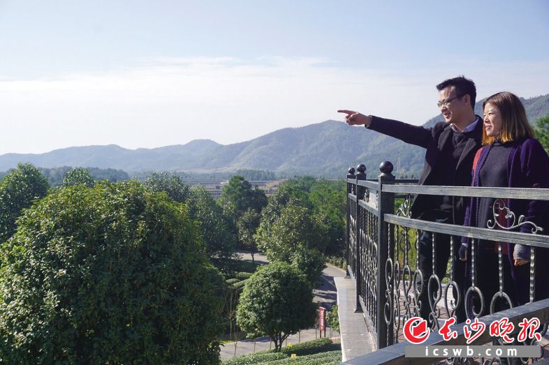 　　龚威威（左）和员工登上湘丰茶博园观景台，放眼望去皆是一片翠绿。蒋盈桂 摄