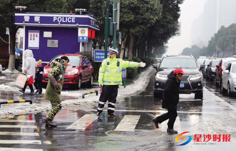 　　长沙县交警在路面执勤，引导行人过马路。章帝 摄