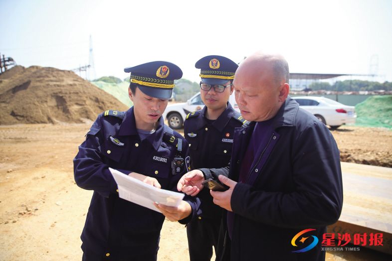 3月23日,陈文武(左一)和同事来到长沙县■梨街道保家村,向一非法洗沙场负责人发放通知,责令其限期搬离。 盛磊 摄