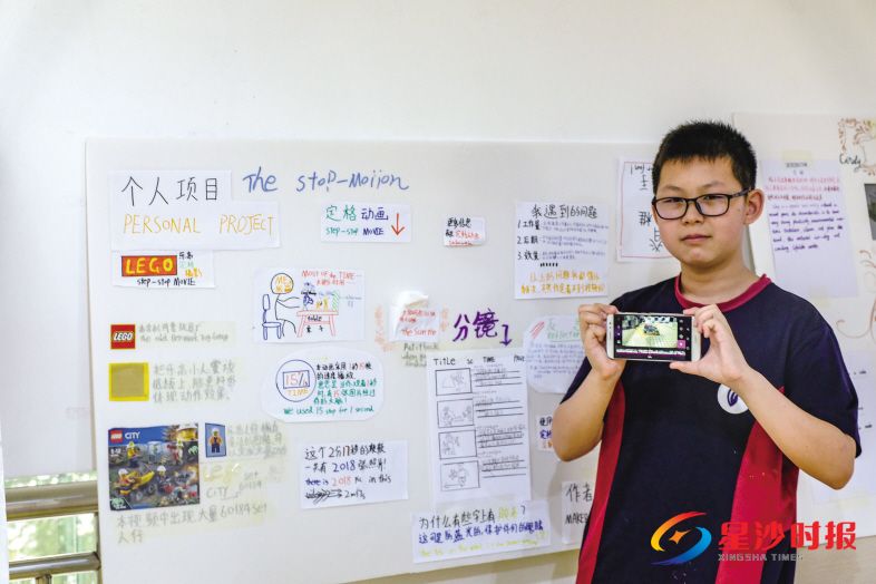 　　八年级的康杰瑞用一台手机和乐高玩具导演了一部充满创意的定格动画影片。图为康杰瑞和他的个人探究展示板。 郑骏 摄