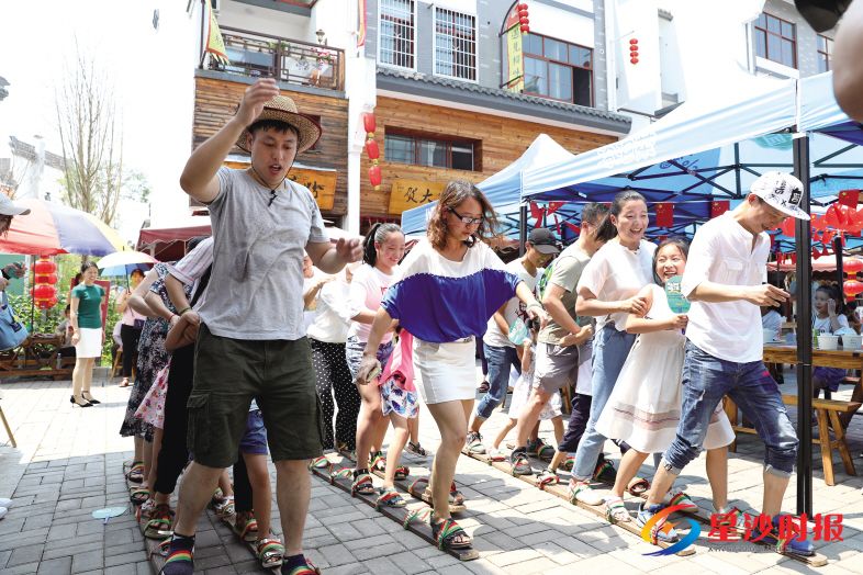 　　6月18日，农历五月初五，在浔龙河美食街，游客们正体验旱龙舟游戏，感受端午文化的乐趣。 蒋炼 摄