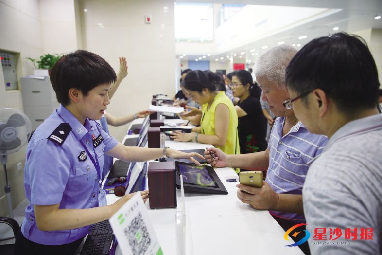 　　6月29日上午，长沙县公安局人口与出入境大队民警张阳指导一名老年群众使用电子填表设备。　　盛磊 摄