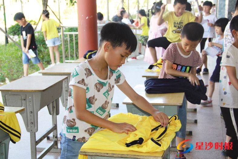 　　游考闯关现场，学生正在比拼叠衣服。潘东晓 摄
