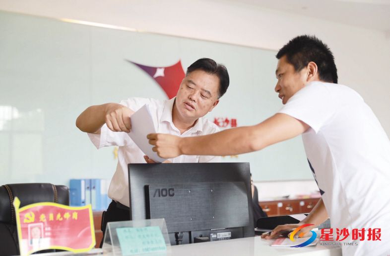 　　在果园镇新明村村民服务中心里，黄季明（左）正在给前来咨询问题的村民耐心地讲解相关政策。章帝 摄