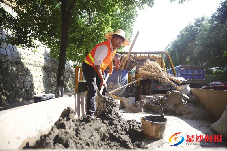 　　昨日下午4时，长沙县市政工人戴和平正在和水泥准备修补路面。