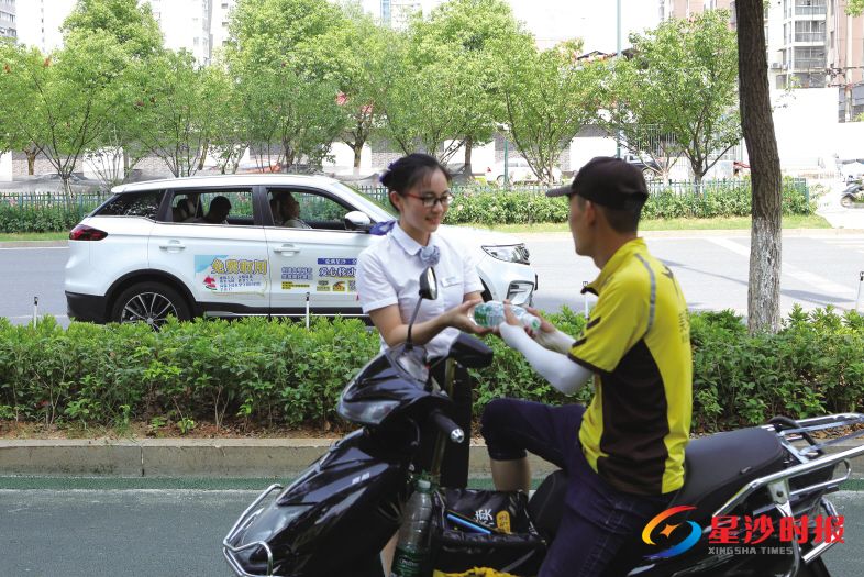 　　长沙华丰汽车贸易有限公司派出三台车作为移动补给点在城区穿梭，为一线劳动者送水解渴。 周煜凯 摄