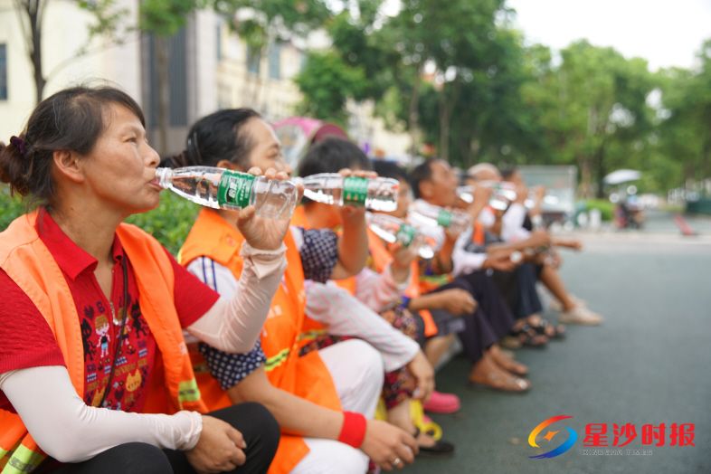 　　环卫工人正在饮用爱心补给站提供的瓶装水。赵鹏 摄