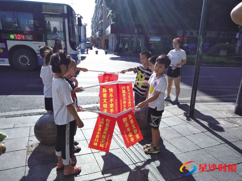 　　孩子们挥着“快乐手牵手，跟着文明走”小旗帜引导行人走斑马线过马路。　　社区供图