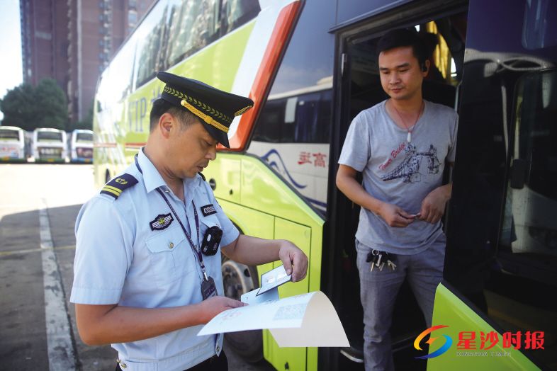 　　长沙县行政执法四分局一中队队员黄洪波在星沙汽车站检查一辆客运车的资质。 　　盛磊 摄