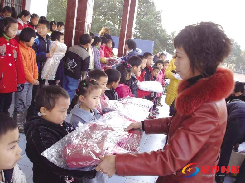 　　何天利（右一）康复后第一时间返回教育岗位。图为何天利给贫困家庭学生送上新书包和新衣服。　　受访者供图