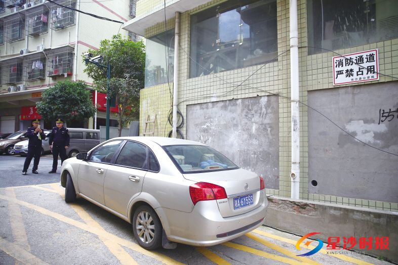 　　↓近日，在城西安置区内，一辆私家车占用消防通道违停，执法人员依法开具罚单。 
