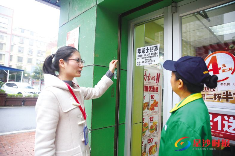 　　近日，湘龙街道潇湘路社区网格干部唐梦敏（左）发现一家餐饮店违规在橱窗上张贴小广告，督促员工及时清除。 盛磊 摄