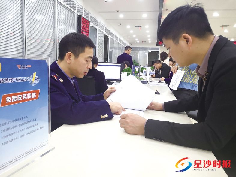 　　长沙经开区工商分局窗口工作人员审核曹伟递交的企业登记材料。蒋云侠 摄