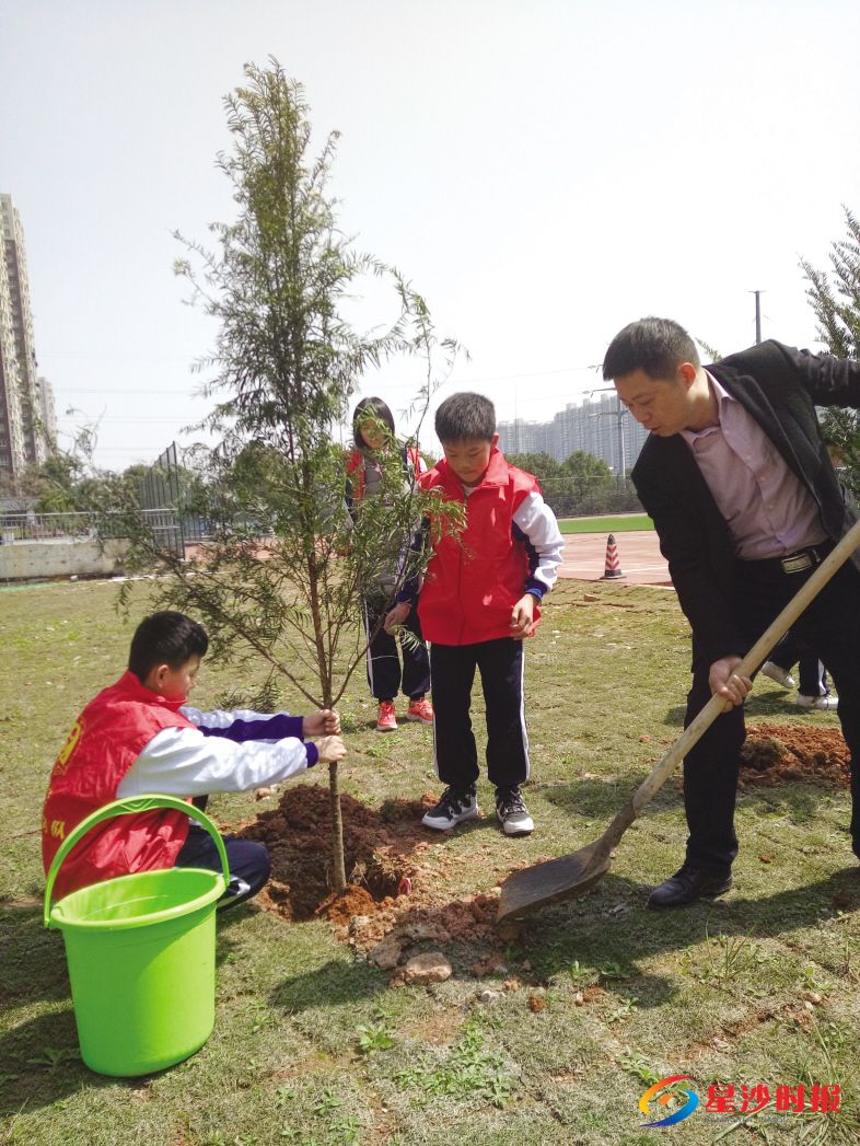 　　天华中学校长蒋湘广与学生一起植树。学校供图