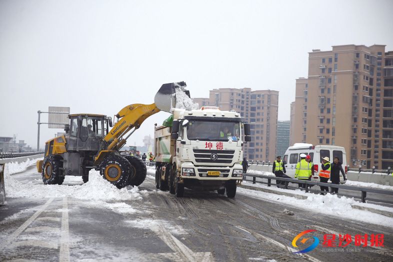 长沙县行政执法局执法队员配合机械作业,完成进出机场通道的扫雪除冰工作。 盛磊 摄