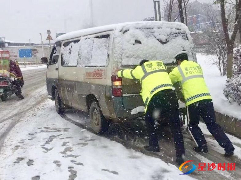 长沙县交警大队全体人员奋战在抗击冰雪一线,为市民保驾护航。图为两名交警正在帮助雪中受困车辆。 县交警大队供图