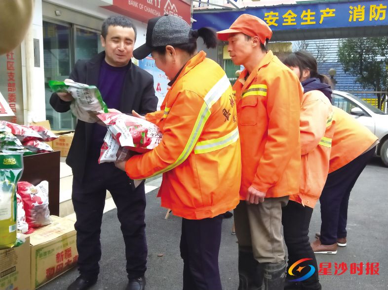 　　1月28日，长沙县湘龙街道潇湘路社区前坪，来自新疆的列提普·图热（左一）正在为环卫工人派发新年“礼包”。宋彬彬 摄
