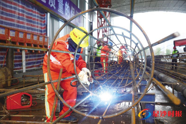 　　2月15日，在位于长沙县范围内的地铁6号线檀木桥站，施工人员使用自动绕筋机制作钢筋笼，平均20分钟可绕一个，既节省了人力，又提高了效率。 盛磊 摄