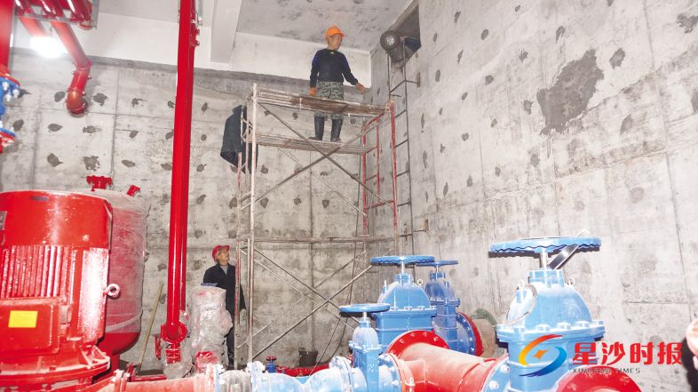 在万家丽路BRT湘龙公交枢纽建设工地内,工人们正在对改项目调度楼负一楼内的消防水池进行防水粉刷。彭帅 摄
