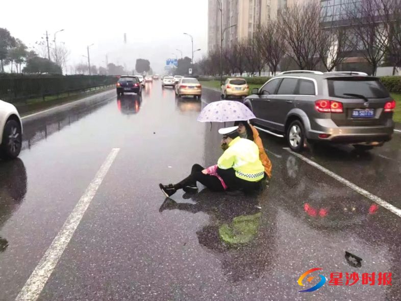 　　2月27日，长沙县交警彭彬在雨中单膝跪地托着交通事故伤者，避免其受到二次伤害，直到救护车到来。交警供图