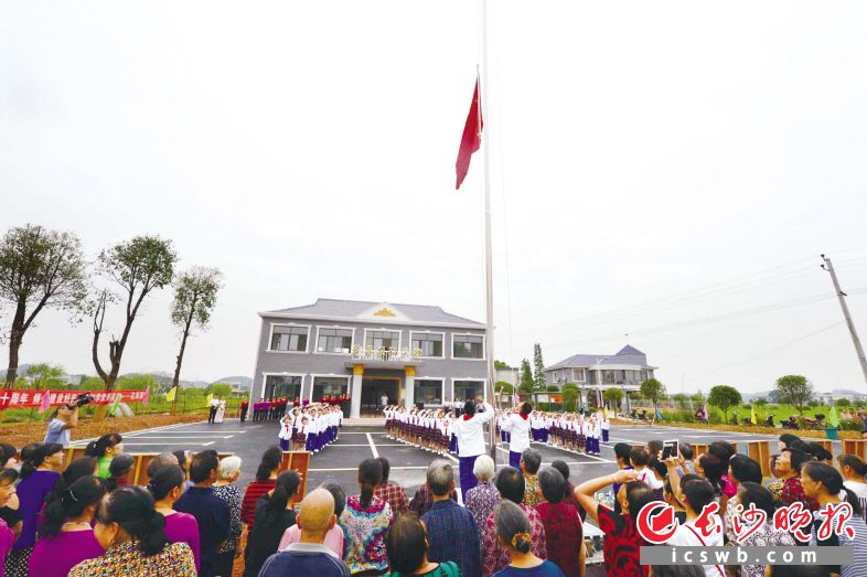 　　22日上午，在长沙县果园镇花果村花果组农民文化广场上，近千名群众和学生升国旗、唱国歌，纪念国歌诞生80周年。　　石祯专 摄