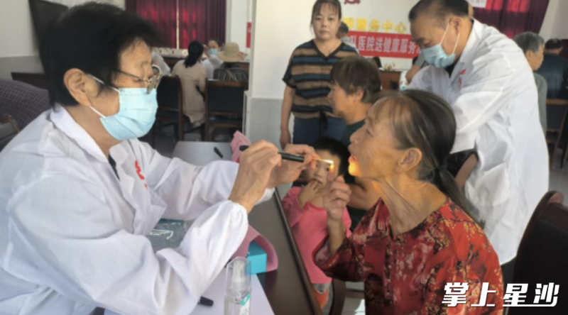 军医在为前来参加义诊的老人接诊检查。
