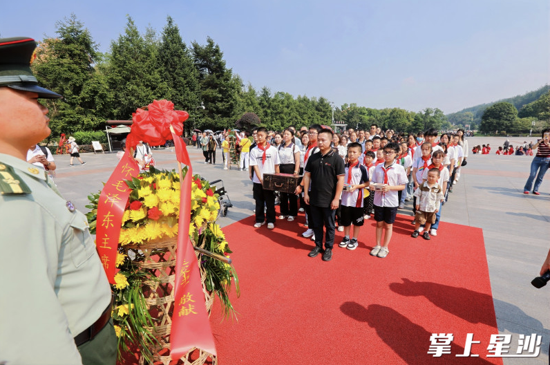学子们向毛泽东铜像敬献花篮。