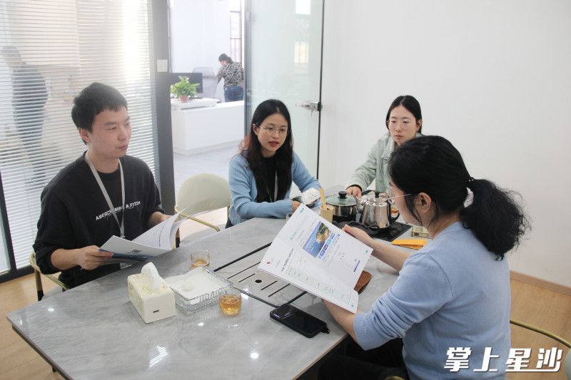 图为江背镇驻企联络员、人才专干走访企业，宣讲政策。