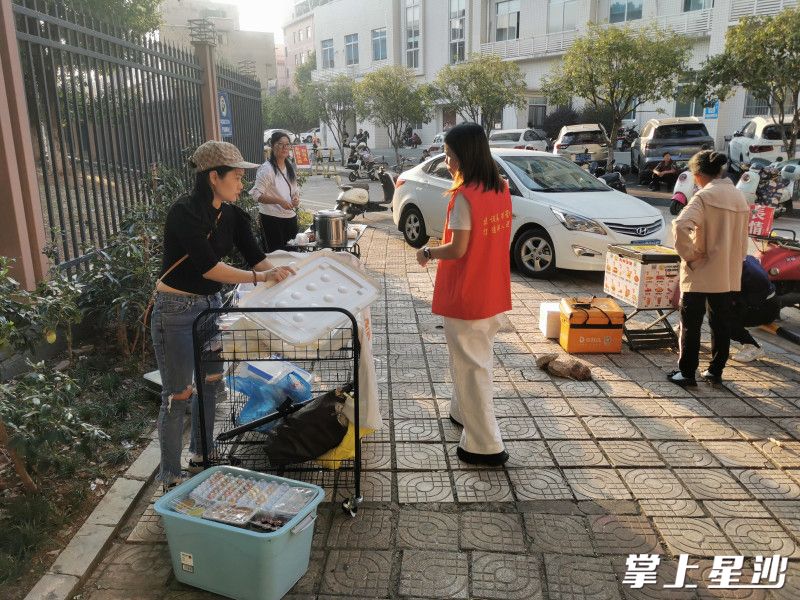 党员志愿者正在丁家小学周边劝导流动摊点。街道供图