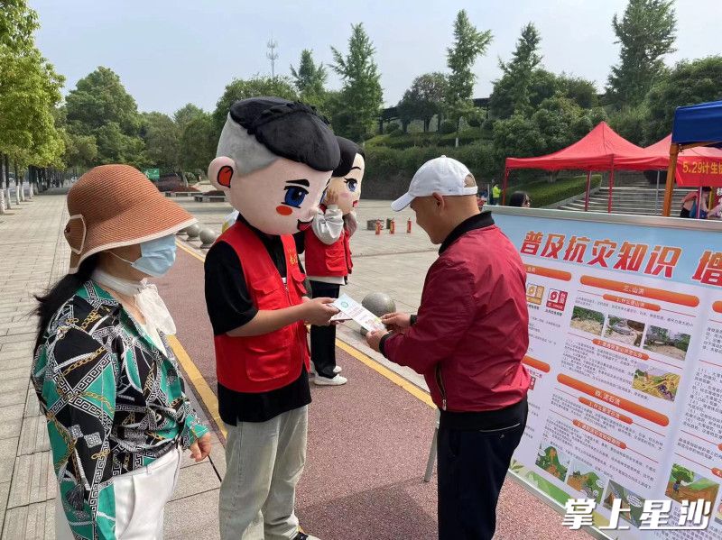 图为“湘哥”“龙妹”给居民发放安全宣传册。街道供图