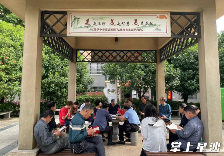 “廉洁凉亭”内，小区党支部书记高英为居民群众讲述起自己的家风故事。社区供图