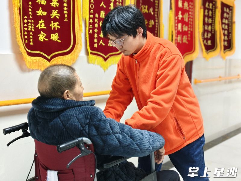 护理员林悦峰为老人整理衣服。长沙县民政局供图