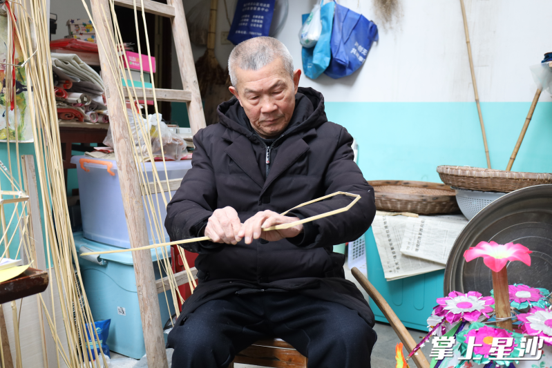 吴乐华正在用竹篾制作滚灯车内灯。均为金井镇供图