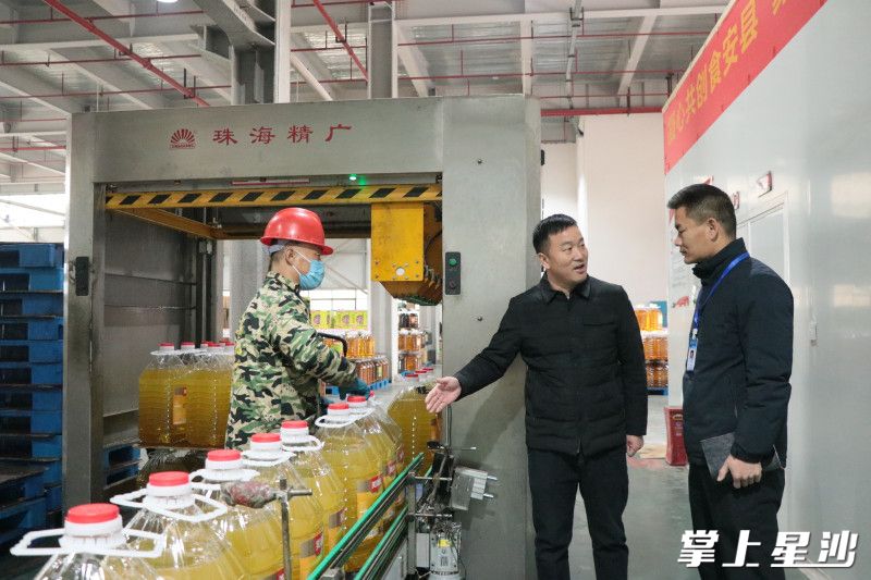 源丰农业运营总监任建波（右二）正在向街道联络员陈志刚介绍智能化生产线生产情况。