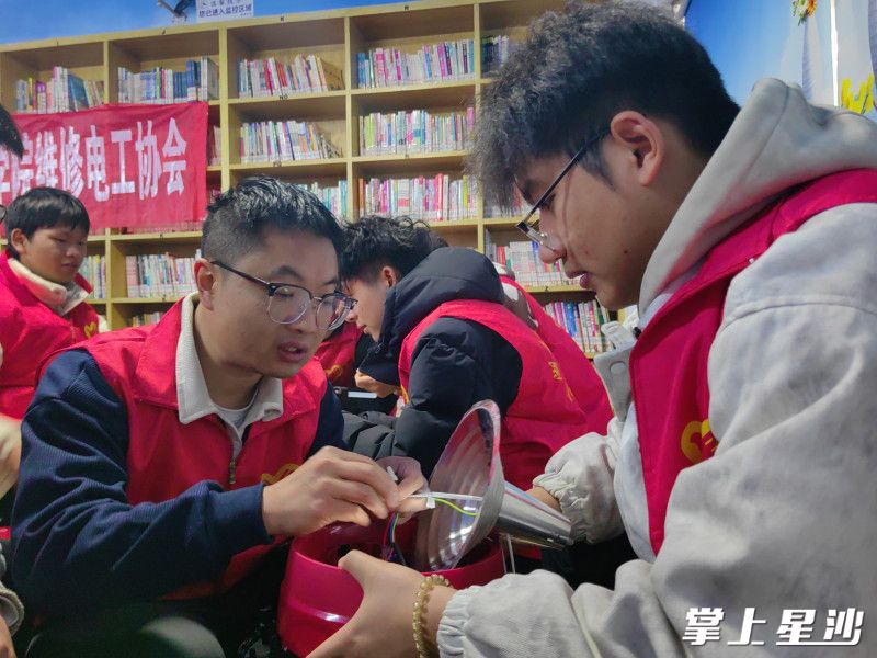 “长沙好人”王彬带领大学生志愿者在未来蜂巢小区为居民义务维修小家电。