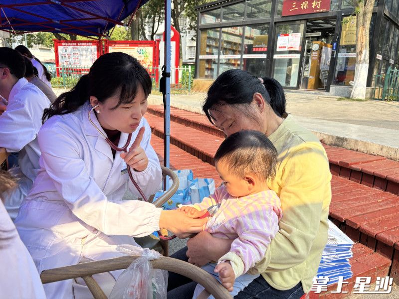 医务人员正在为儿童进行义诊。周汝洁 摄