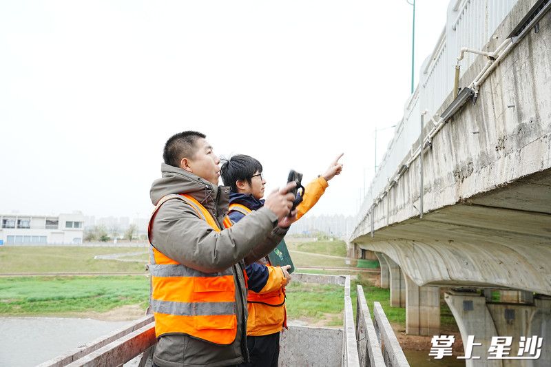 工作人员正在查看桥梁裂缝宽度是否增加、修复处是否出现新裂缝等。