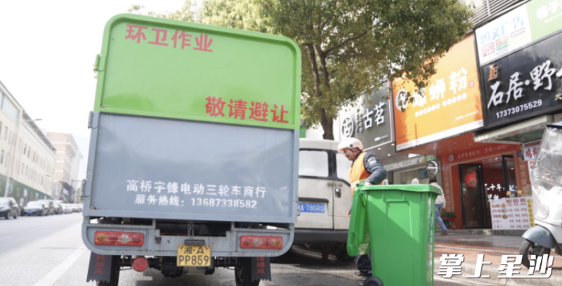 负责龙喜路上垃圾清运的环卫工人正在准备倾倒垃圾。