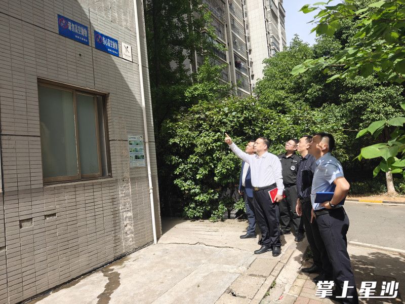 县住房和城乡建设局工作人员和物业人员正在检查外墙脱落情况。彭娴 摄