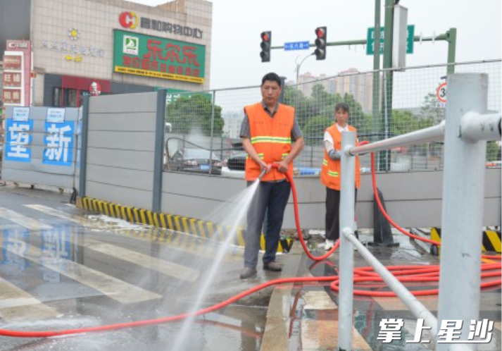 环卫工人正在认真冲洗路面。
