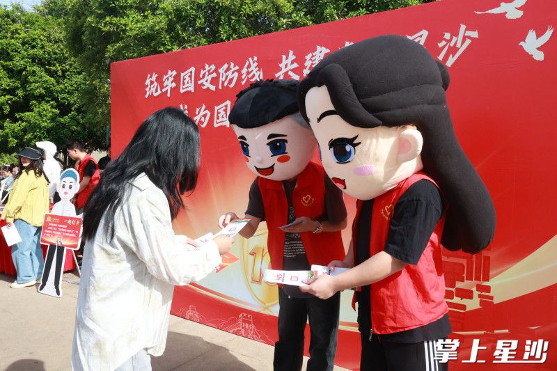 “湘哥”“龙妹”向经过的居民们发放全民国家安全教育主题宣传折页。