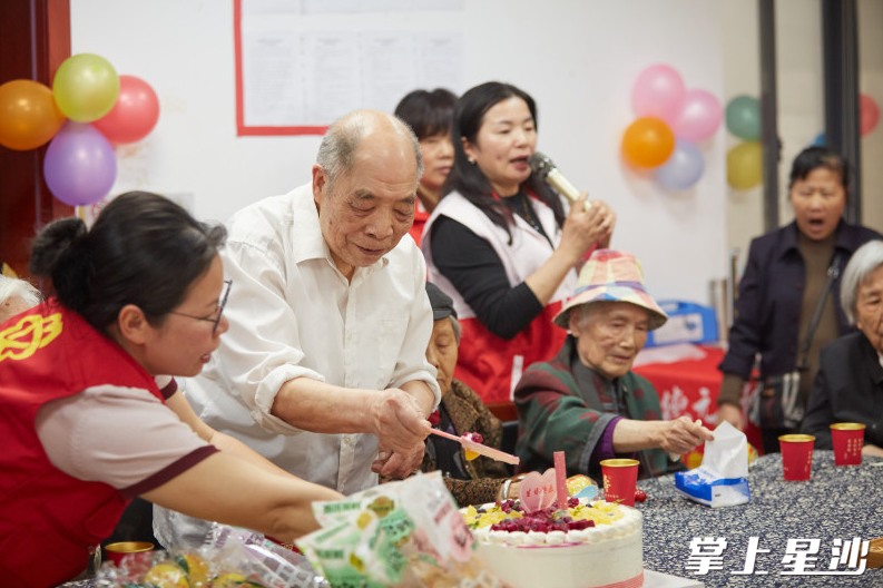 91岁的老党员王根友开心地切蛋糕。均为志愿者丁红亮 摄