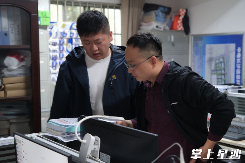 图为房建管理部工作人员查看项目设计资料。均为李杰 摄