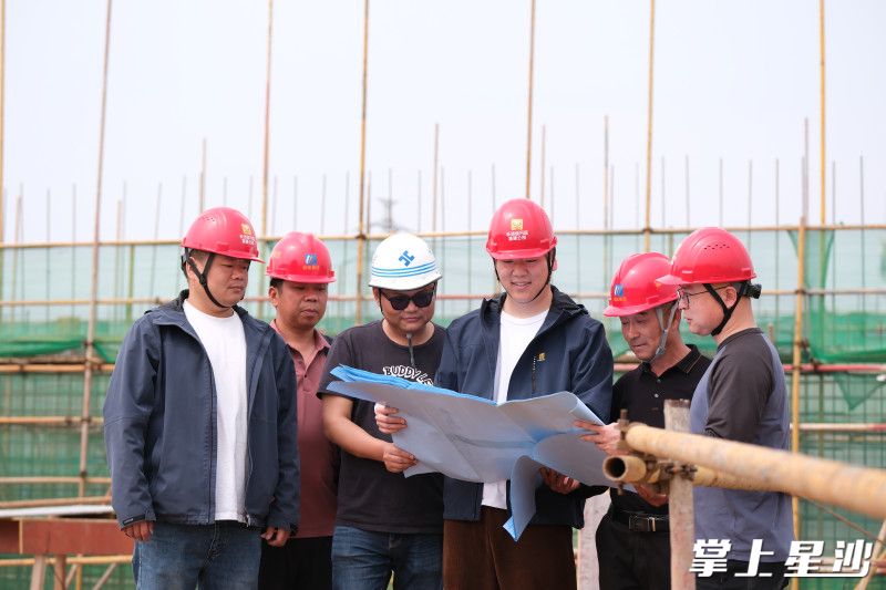 房建管理部工作人员对照项目设计图纸查看建设情况。