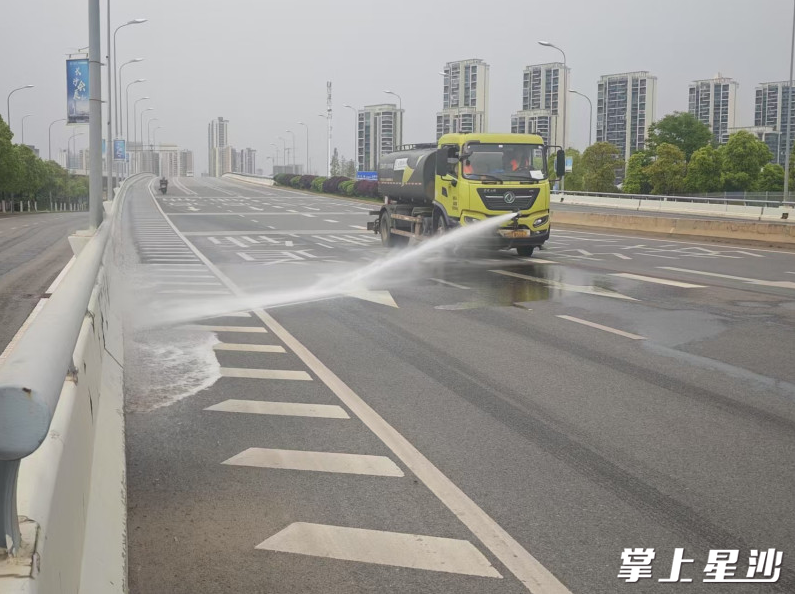 黄兴镇洒水车冲扫马路。