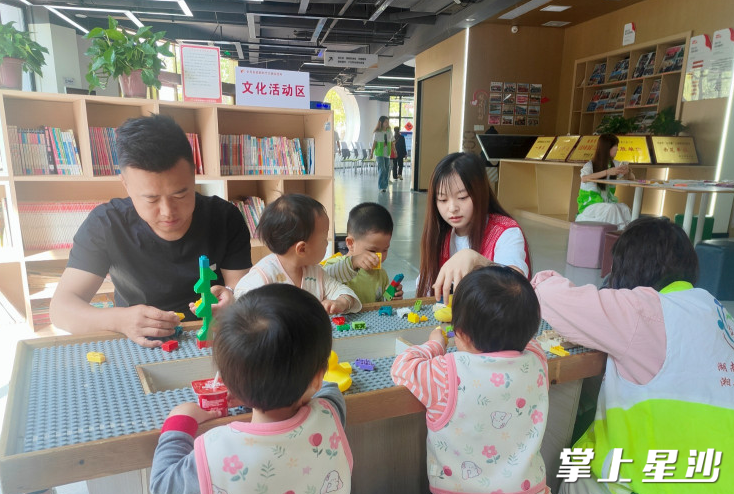 家长与孩子在志愿者的协助下开展亲子互动。
