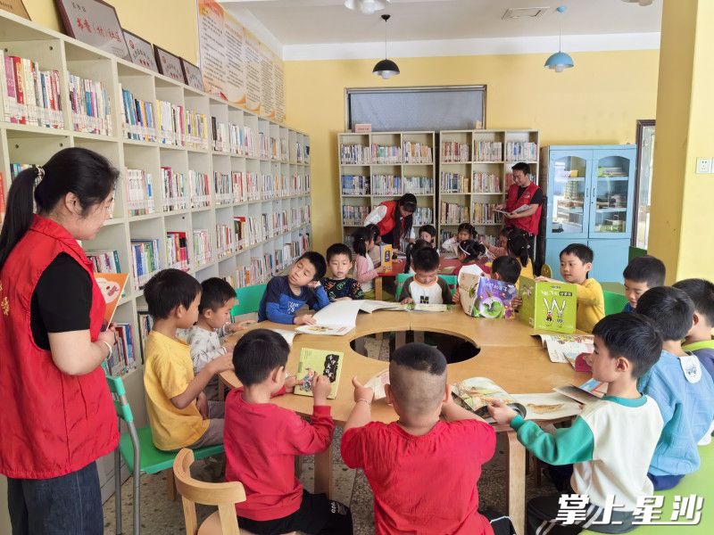 长沙县金井镇金龙村开展阅读活动,孩子们被书中的知识吸引。通讯员供图