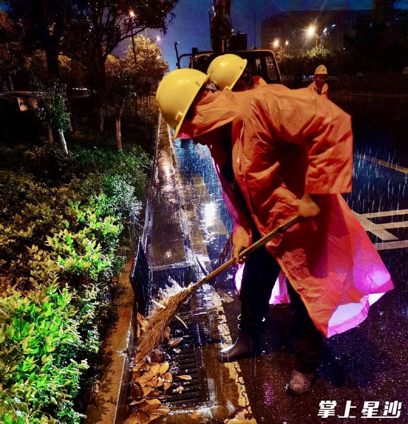 市政工人正准备打开雨水篦子促排。