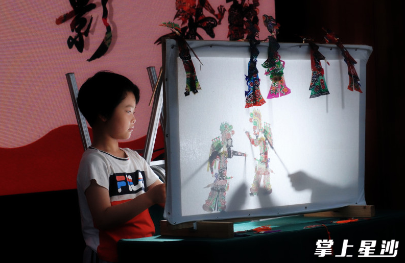 孩子们体验皮影戏。