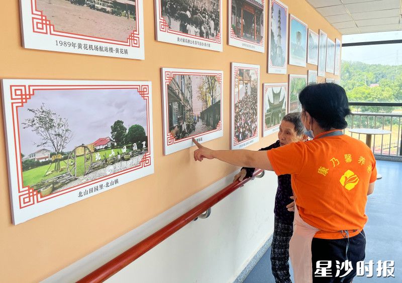 护理员杨发辉陪伴老人在长沙县历史文化区开展“老照片回忆”康复训练。高桥镇敬老院供图